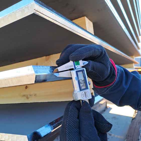 Digital caliper measurement of steel plate thickness during supplier inspection